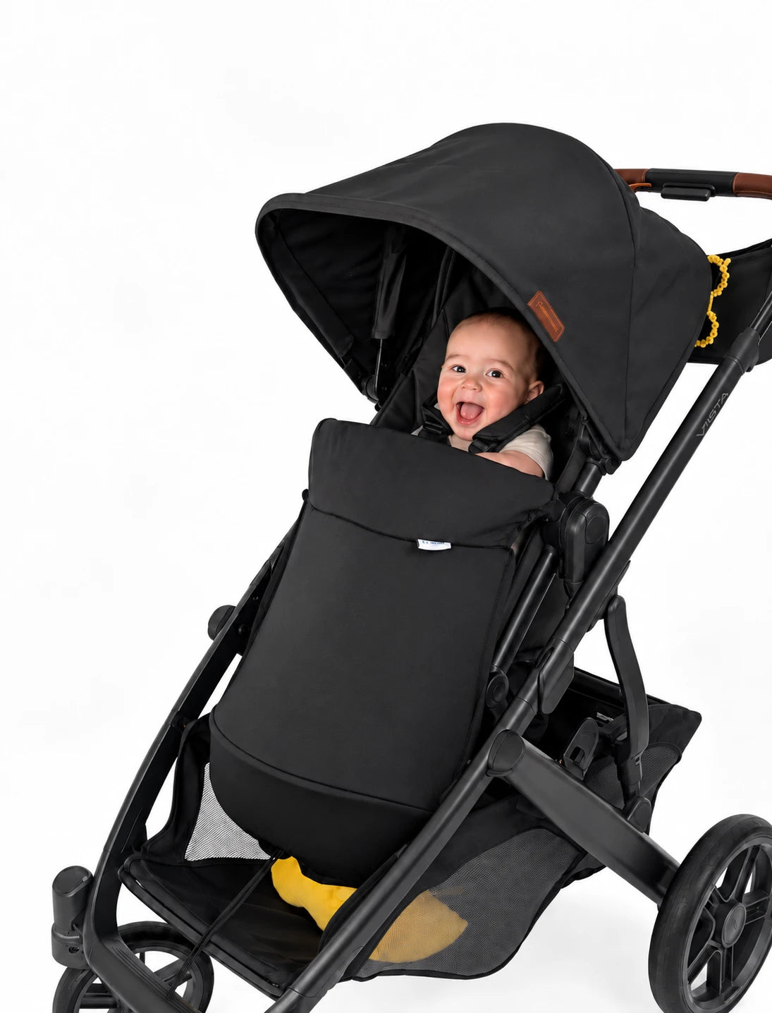 Smiling baby in a black pram with the COVR Signature Shade covering their legs